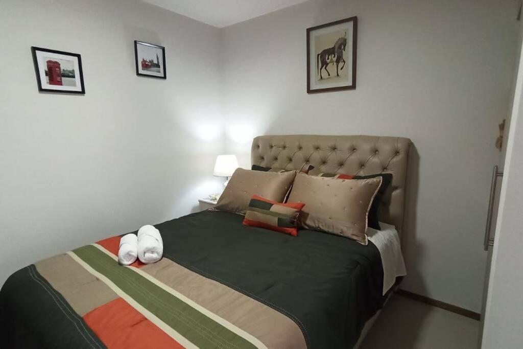 um quarto com uma cama grande e almofadas em Monoambiente de Lujo en EL PRADO de Cochabamba II em Cochabamba