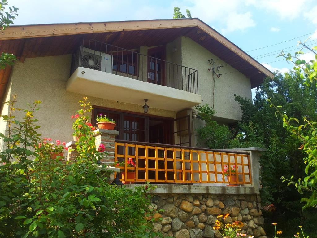 a house with an orange gate and a balcony at Къща за гости Каза Роза - Swiss Style Chalet Casa Rosa Guest House in Kyustendil