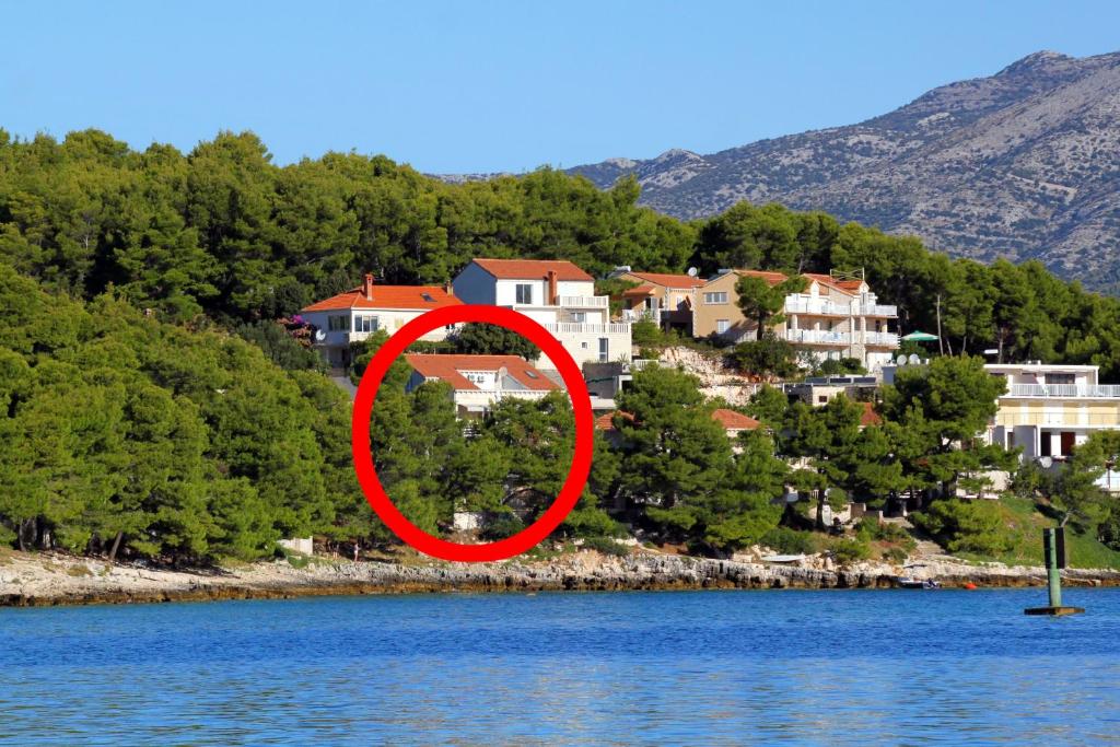 a house in the middle of a lake with houses at Apartments by the sea Lumbarda, Korcula - 9260 in Lumbarda