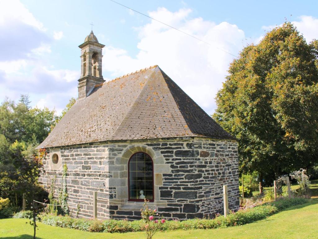 une ancienne église en pierre avec une cloche dans l'établissement Cottage Chapel, Briec, à Briec