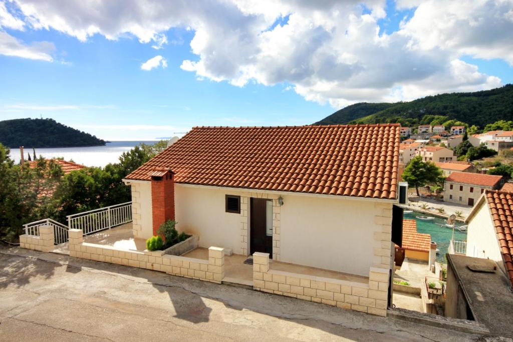 ein weißes Haus mit einem roten Dach mit Aussicht in der Unterkunft Apartments by the sea Brna, Korcula - 9187 in Brna