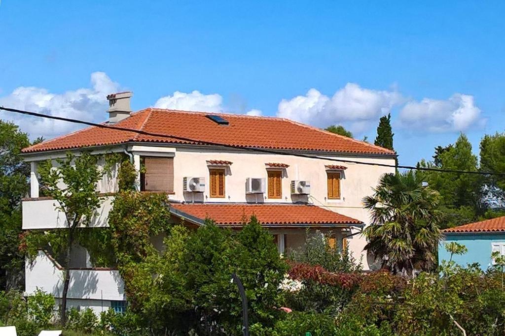a large white house with an orange roof at Apartment Nerezine 8049b in Nerezine
