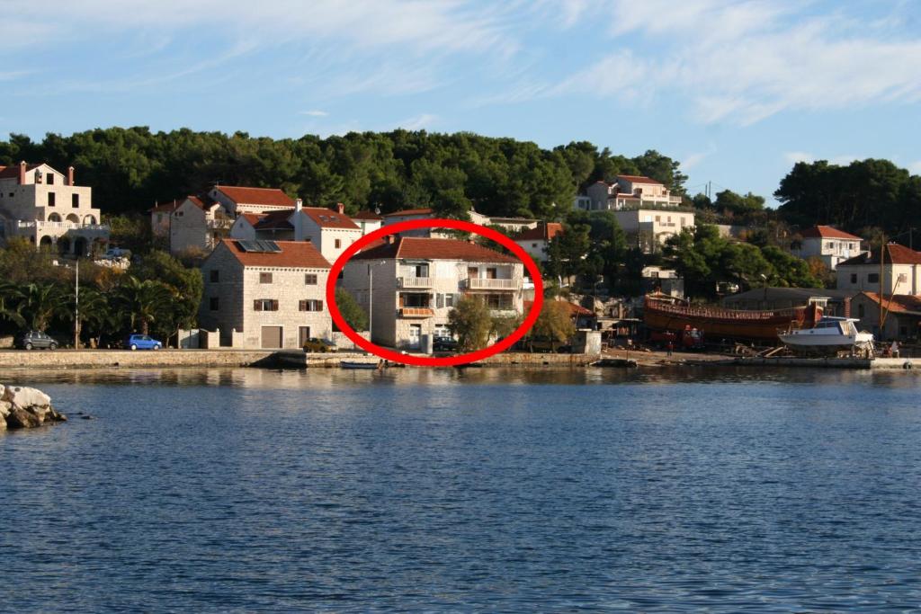 a house in a red circle next to a body of water at Apartments and rooms by the sea Sumartin, Brac - 2953 in Sumartin