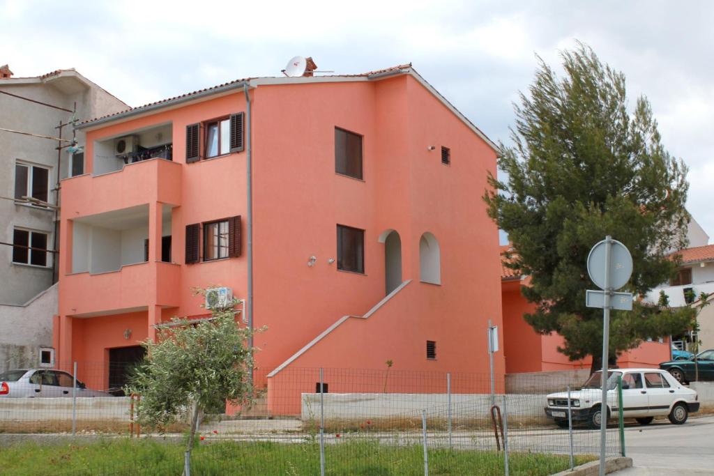 pomarańczowy budynek ze schodami na boku w obiekcie Apartments with a parking space Pula - 7664 w Puli