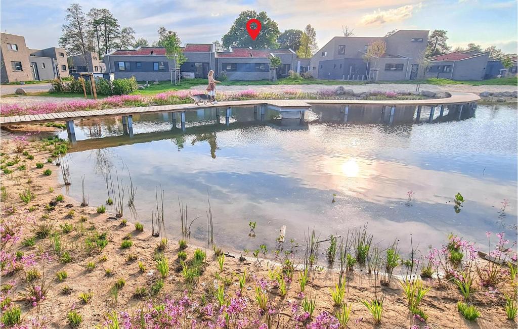 a woman is standing on a bridge over a pond at Nice Home In Lembruchdümmer See in Lembruch