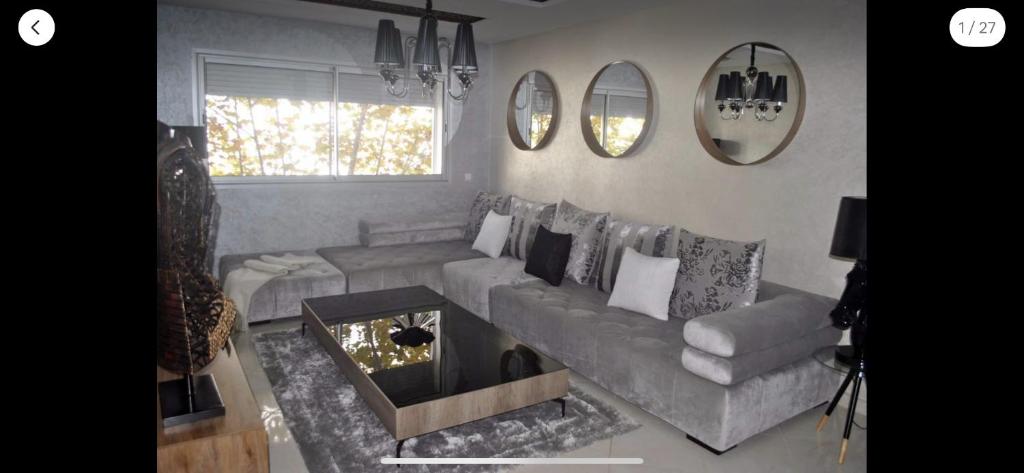 Luxury apartment in downtown of kenitra في القنيطرة: غرفة معيشة مع أريكة وطاولة
