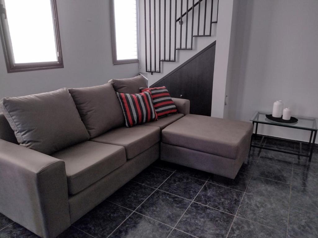 ein braunes Sofa im Wohnzimmer mit einer Treppe in der Unterkunft Apartamento Agur cerca del Arena Stadium in Maipú