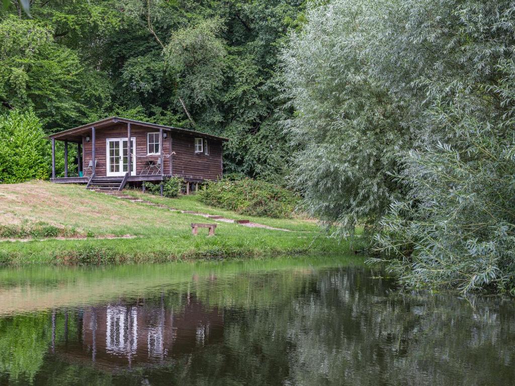 a small cabin on the side of a lake at Lakeside Cabin in Dunkeswell