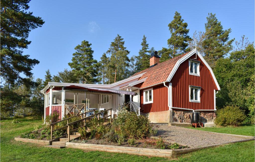 a red house with a garden in front of it at Amazing Home In Hagalundmjölby in Mjölby