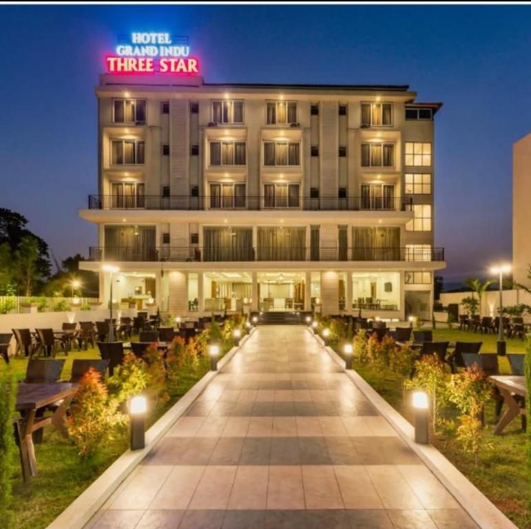 un hotel con un cartel de tres estrellas frente a un edificio en Hotel Grand Indu, 3 Star Kolhapur, en Kolhapur