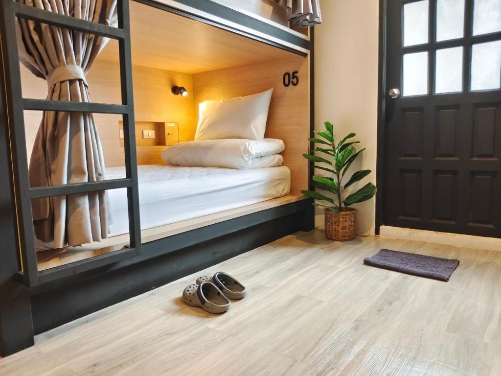 a bedroom with a bed with a mirror and a pair of shoes at Hope Hostel Hatyai in Hat Yai