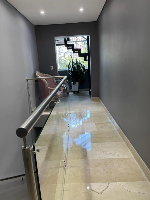 a hallway with a glass staircase with a potted plant at Soho Suite Hotel in Medellín