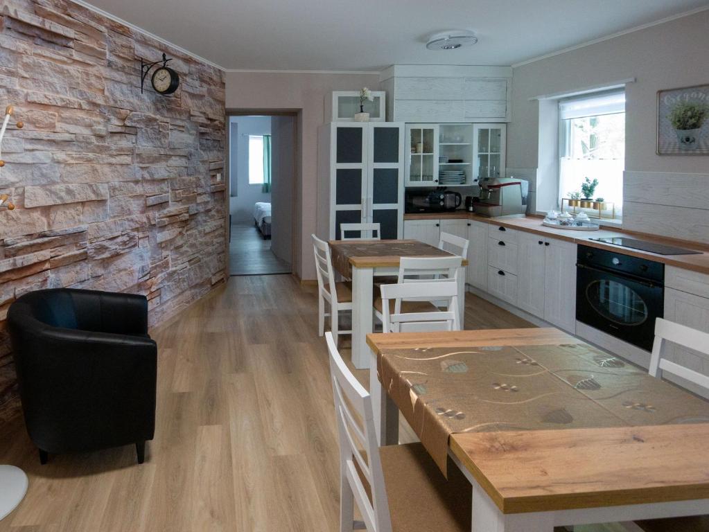 kuchnia z ceglaną ścianą oraz stołem i krzesłami w obiekcie Bokor vendégház - Levendula apartman w mieście Szentes