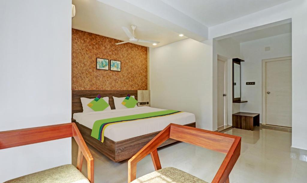 a bedroom with a bed and a table in it at Treebo Trend Sreepathi Mayoogha in Guruvāyūr