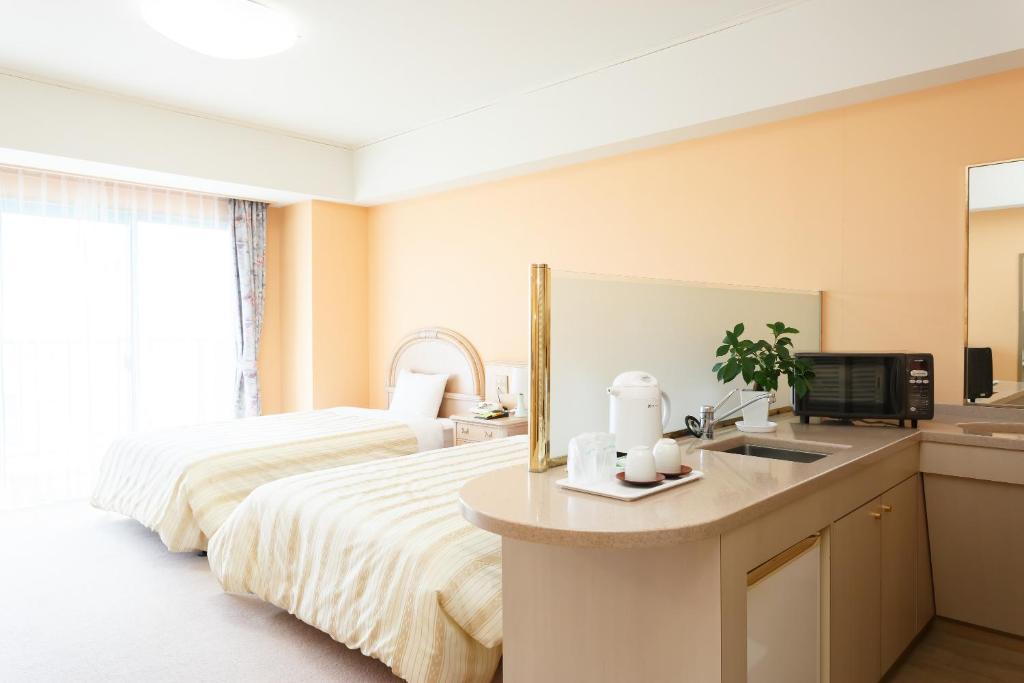 Pokój hotelowy z łóżkiem i umywalką w obiekcie Hotel Bell Harmony Ishigaki Island w mieście Ishigaki