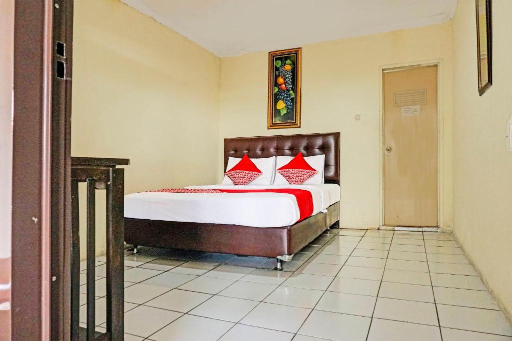 - une chambre avec un grand lit et des oreillers rouges dans l'établissement Cunang Hill Hotel & Resort, à Bogor