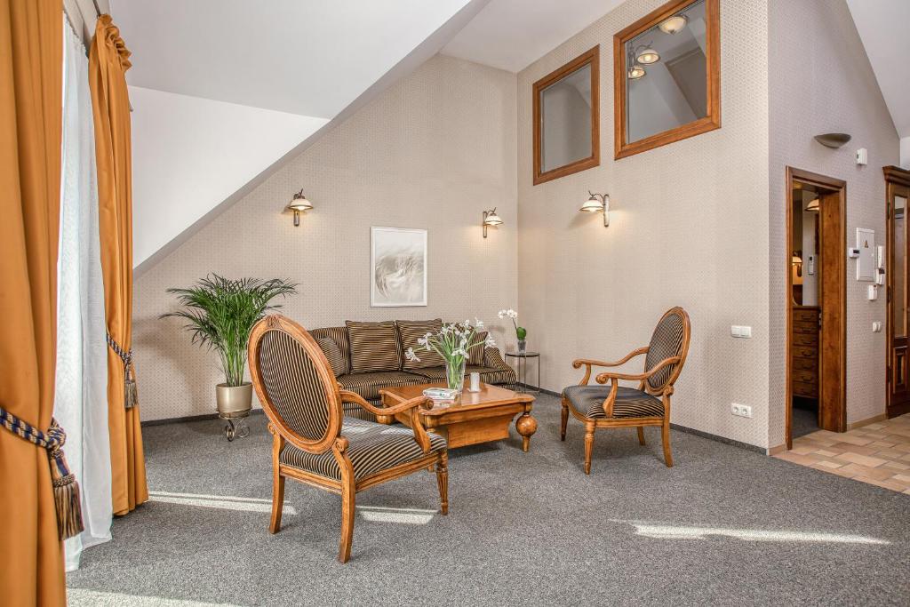 a living room with a couch and chairs at White Lily Apartment in Klaipėda