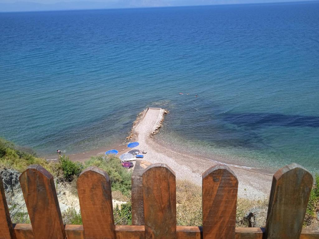 uma vista para a praia a partir de uma cerca de madeira em Niforeika panorama em Kato Achaia