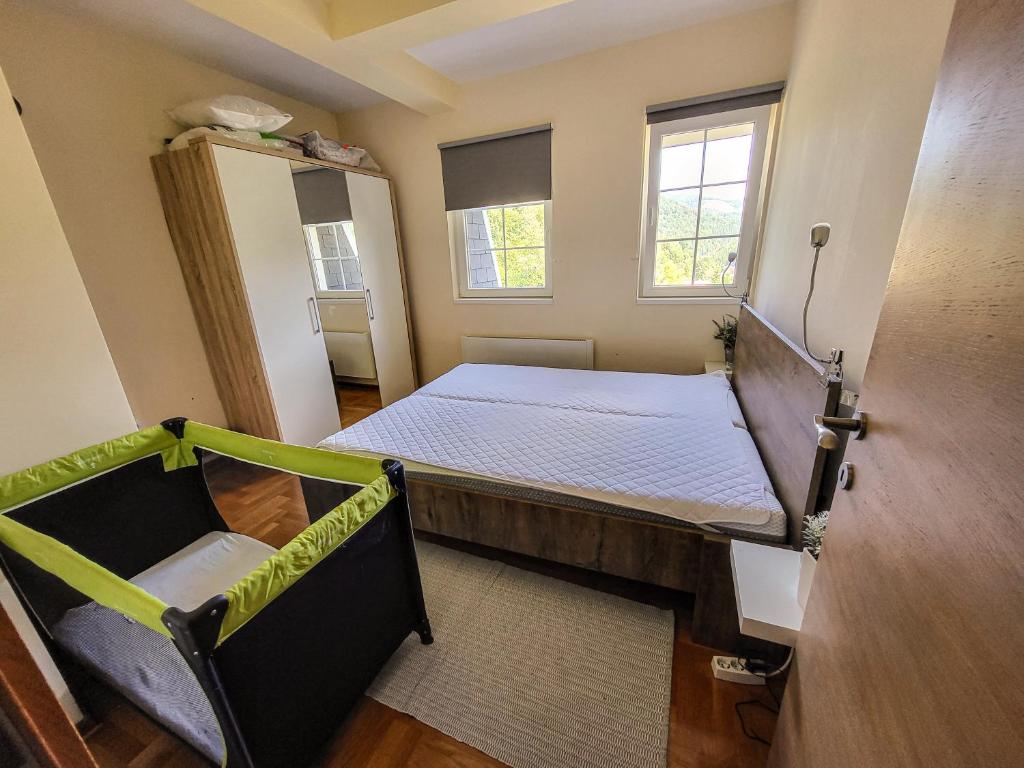 Schlafzimmer mit einem Bett und einem Fenster in der Unterkunft STAR apartman Brzece Kopaonik in Brzeće