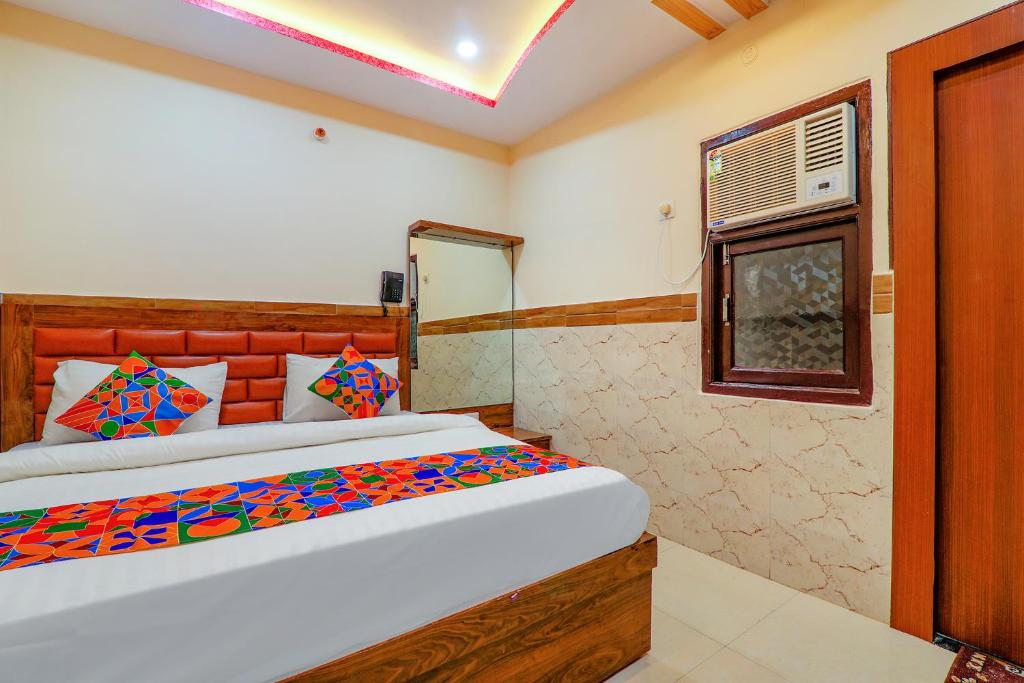 een slaapkamer met een bed en een raam bij FabExpress Shree Galaxy in Kānpur