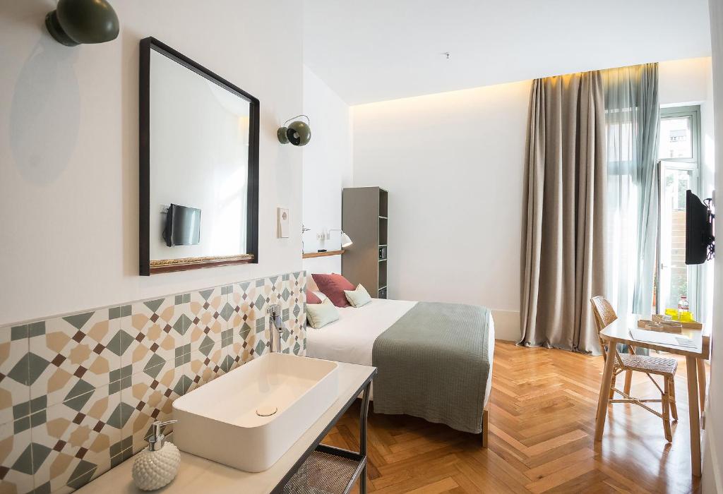 Habitación de hotel con cama y espejo en Casa Mathilda en Barcelona