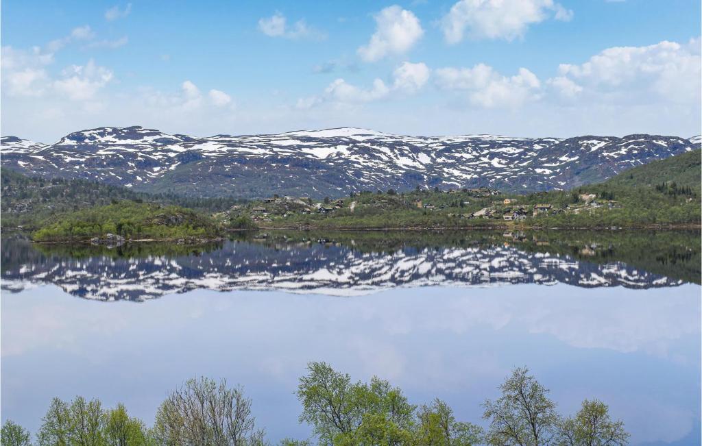 un reflejo de montañas cubiertas de nieve en un lago en Stunning Apartment In Vgslid With Wifi en Vågsli