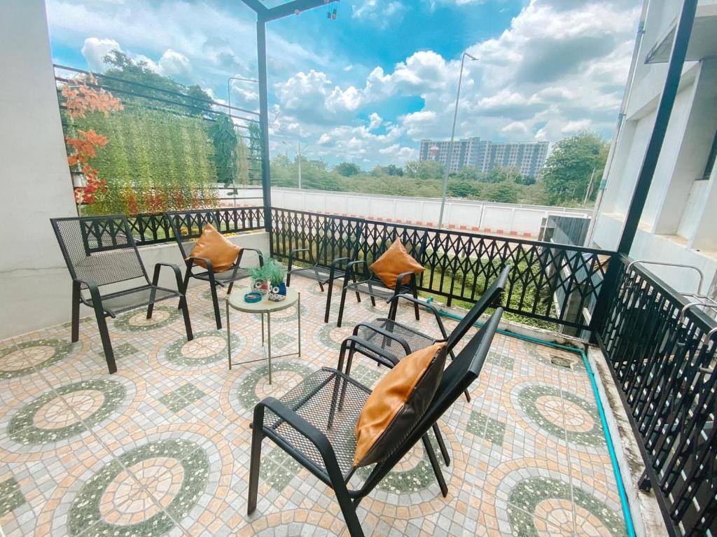 balcón con sillas y mesas y vistas al río en Sleep Owl Hostel en Bangkok