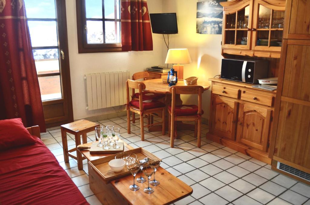 ein Wohnzimmer mit einem Tisch und einer Küche in der Unterkunft Granges 8 - BEL APPT 4P AU PIED DES PISTES DOMAINE ALPE D'HUEZ in Villard-Reculas