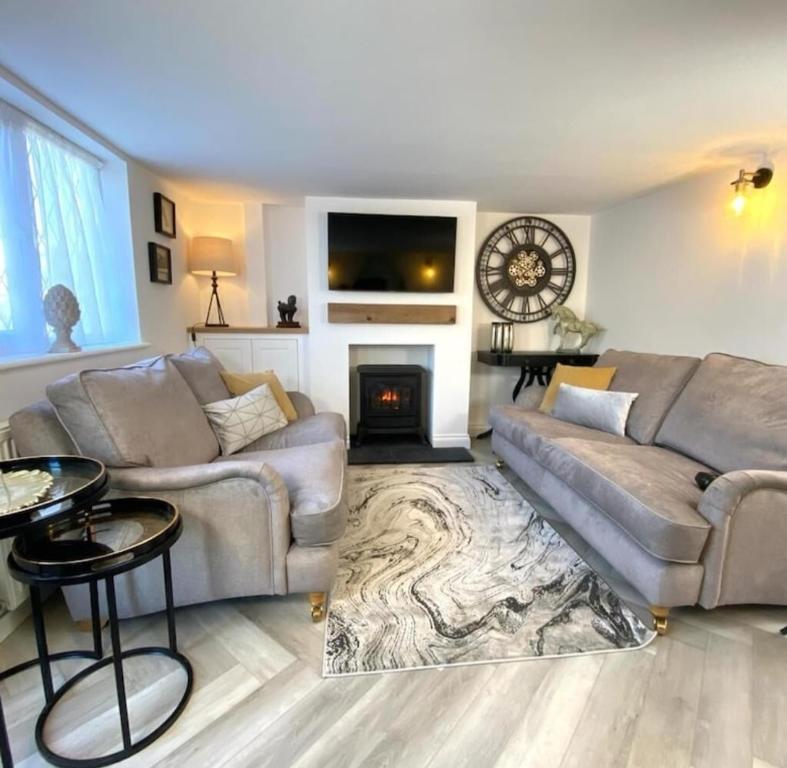 a living room with a couch and a fireplace at Cosy cottage 5 minutes walk to beach in Caister-on-Sea