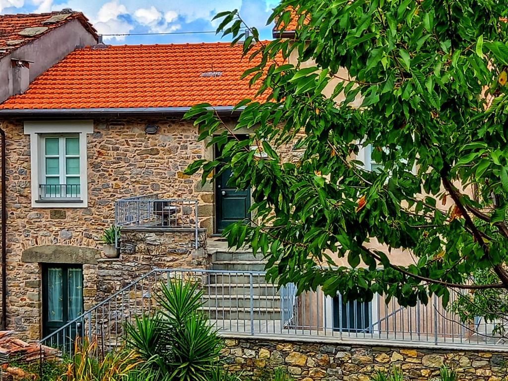 een stenen huis met een trap en een rood dak bij Casa Natale in Corvara