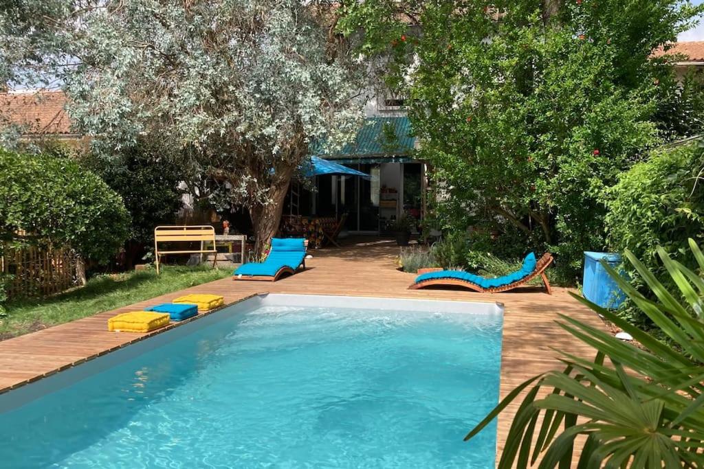 einen Pool mit blauen und gelben Stühlen und Bäumen in der Unterkunft Bordeaux centre, 5 chambres privées, piscine, parking in Bordeaux