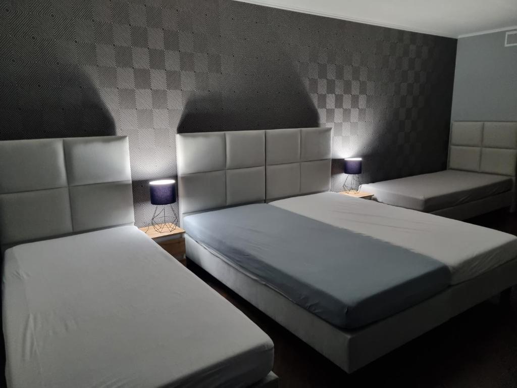 dwa łóżka w małym pokoju z dwoma lampami w obiekcie Villa Akacjowa w mieście Turbia