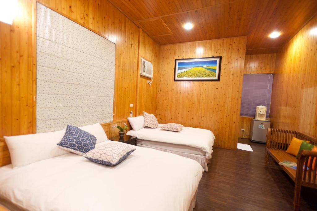 two beds in a room with wooden walls at Bay of Stars in Ji&#39;an