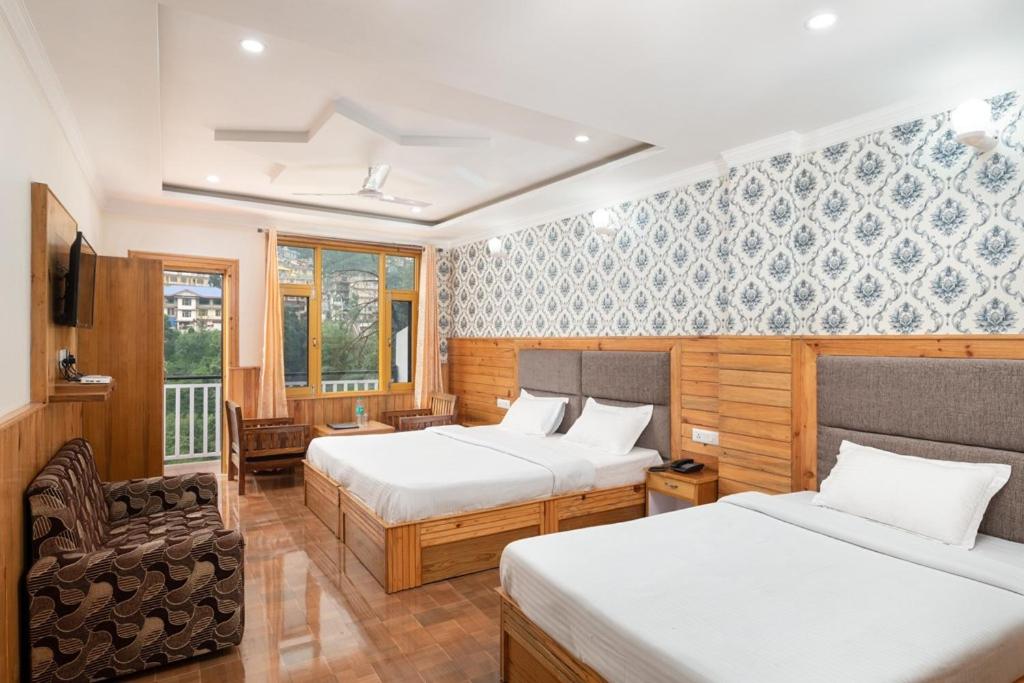 a hotel room with two beds and a chair at Mcleodgunj Mountain view in Dharamshala