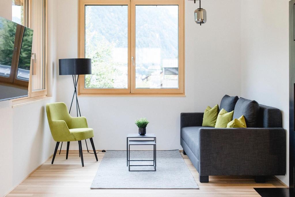 uma sala de estar com um sofá e uma cadeira em am Greben Apartments eins - zwei - sechs - sieben em Bezau