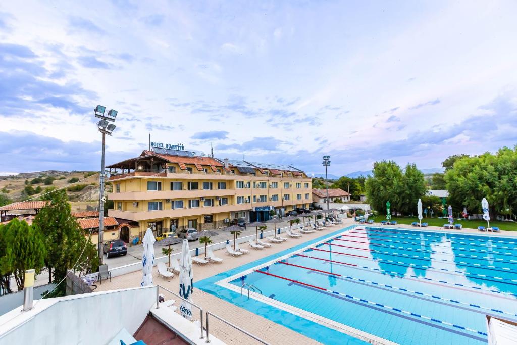 a large swimming pool with chairs and a hotel at Komitite Complex in Chuchuligovo
