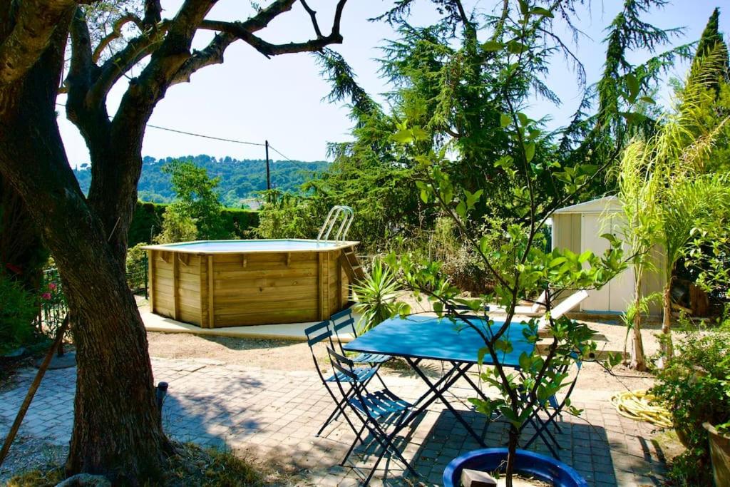 eine Terrasse mit einem Tisch und Stühlen sowie einer Holzbadewanne in der Unterkunft L'ATELIER - Piscine - Dans les vignes - Cassis in Cassis