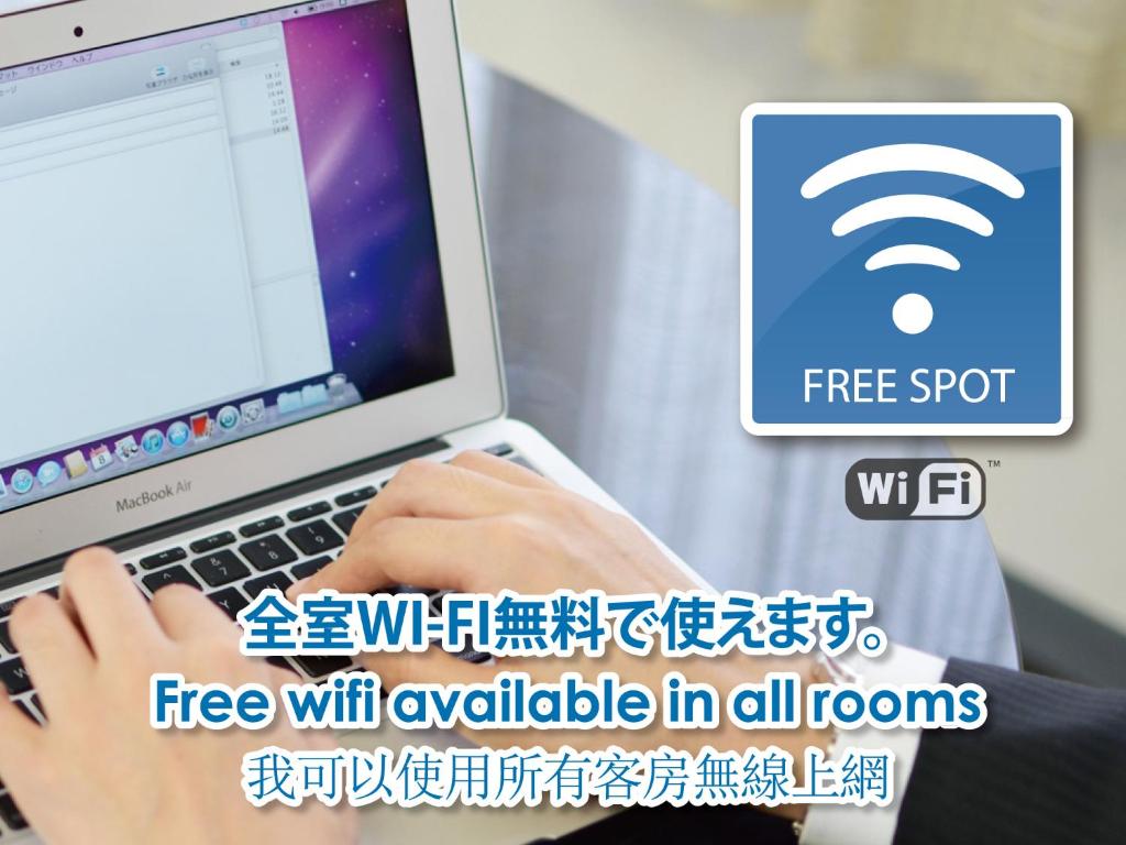 a person typing on a laptop computer with a free wifi sign at Hotel Abest Naha Kokusaidori in Naha