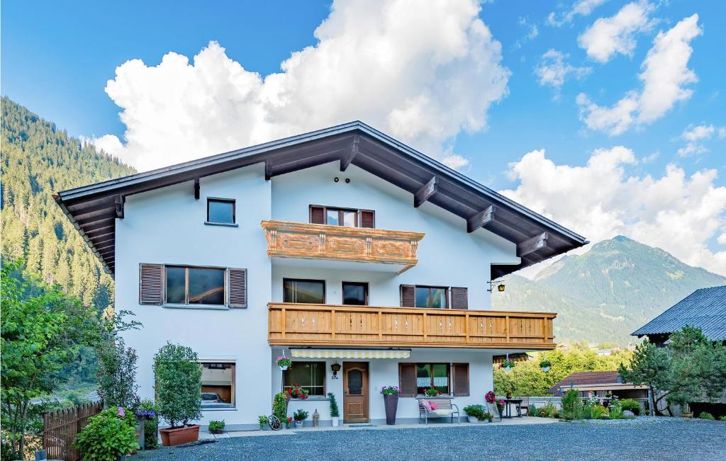 a house with a balcony and mountains in the background at Beautiful Home In St, Gallenkirch With 6 Bedrooms, Sauna And Wifi in Aussersiggam