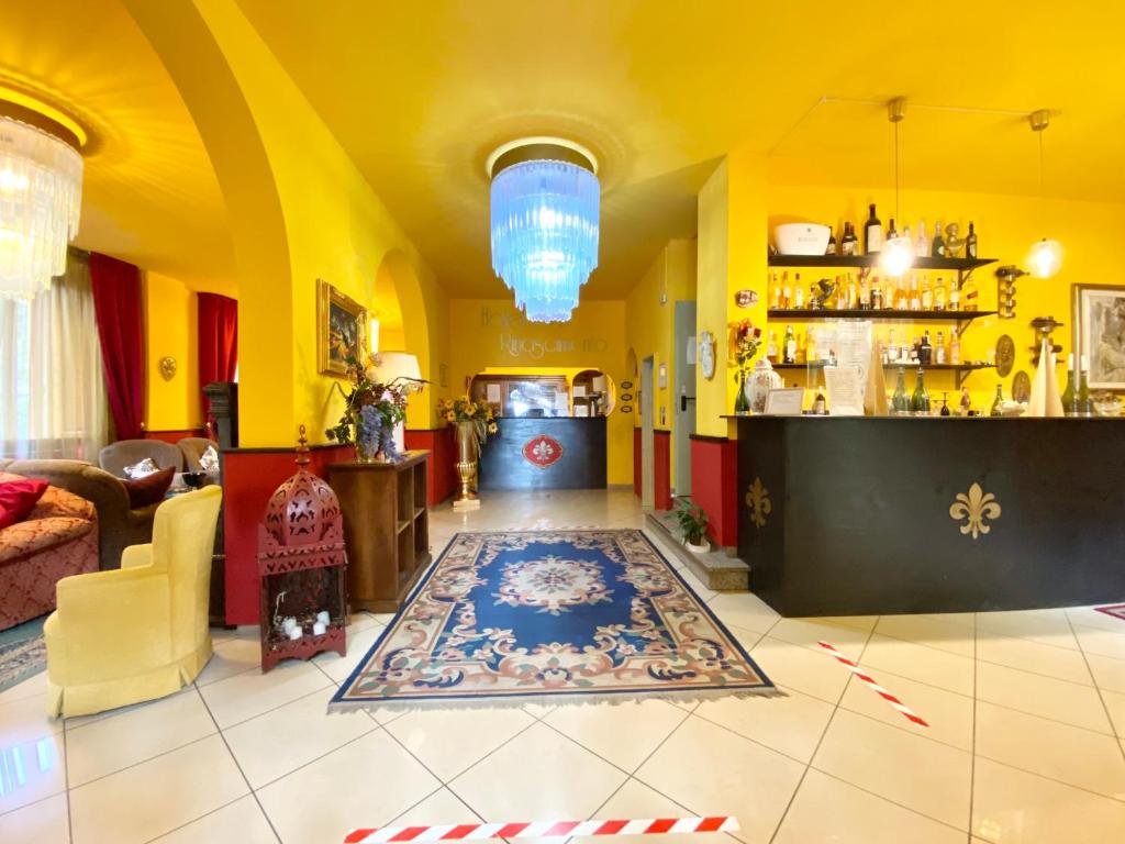 een lobby met gele muren en een tapijt op de vloer bij HOTEL RINASCIMENTO in Montecatini Terme