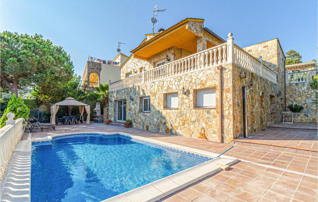Villa con piscina frente a una casa en Awesome Home In Palafolls With Outdoor Swimming Pool, en Palafolls