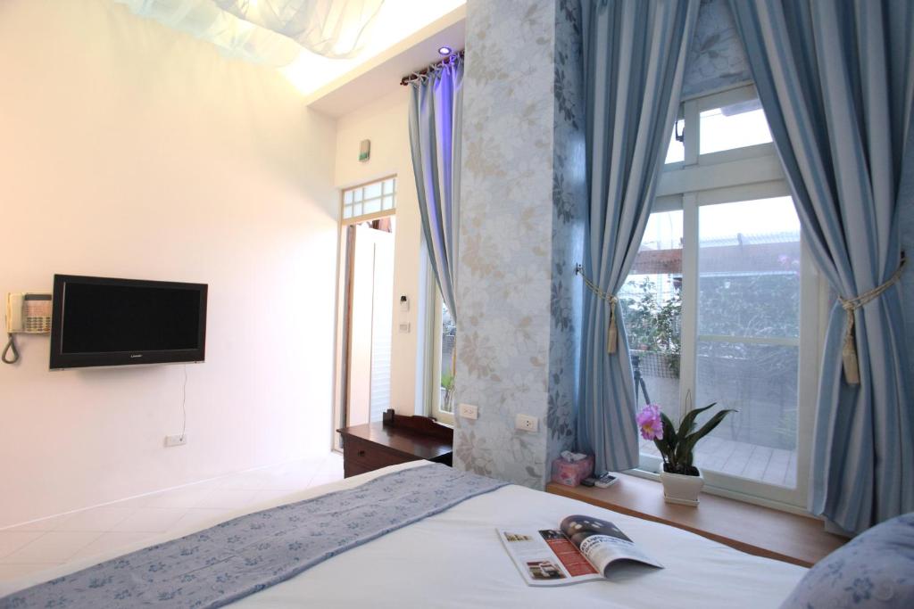 a bedroom with a bed with a tv and a window at Bay of Stars in Ji&#39;an