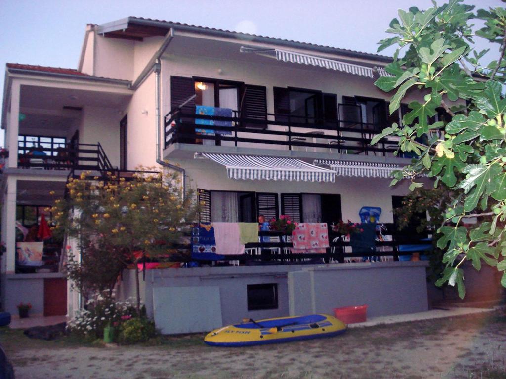 a house with a yellow kayak in front of it at Apartments Jurlina in Seline