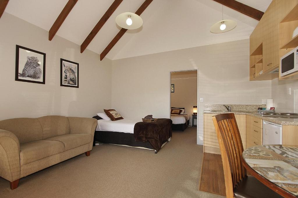 sypialnia z łóżkiem i kanapą w pokoju w obiekcie Big Five Motel w mieście Palmerston North