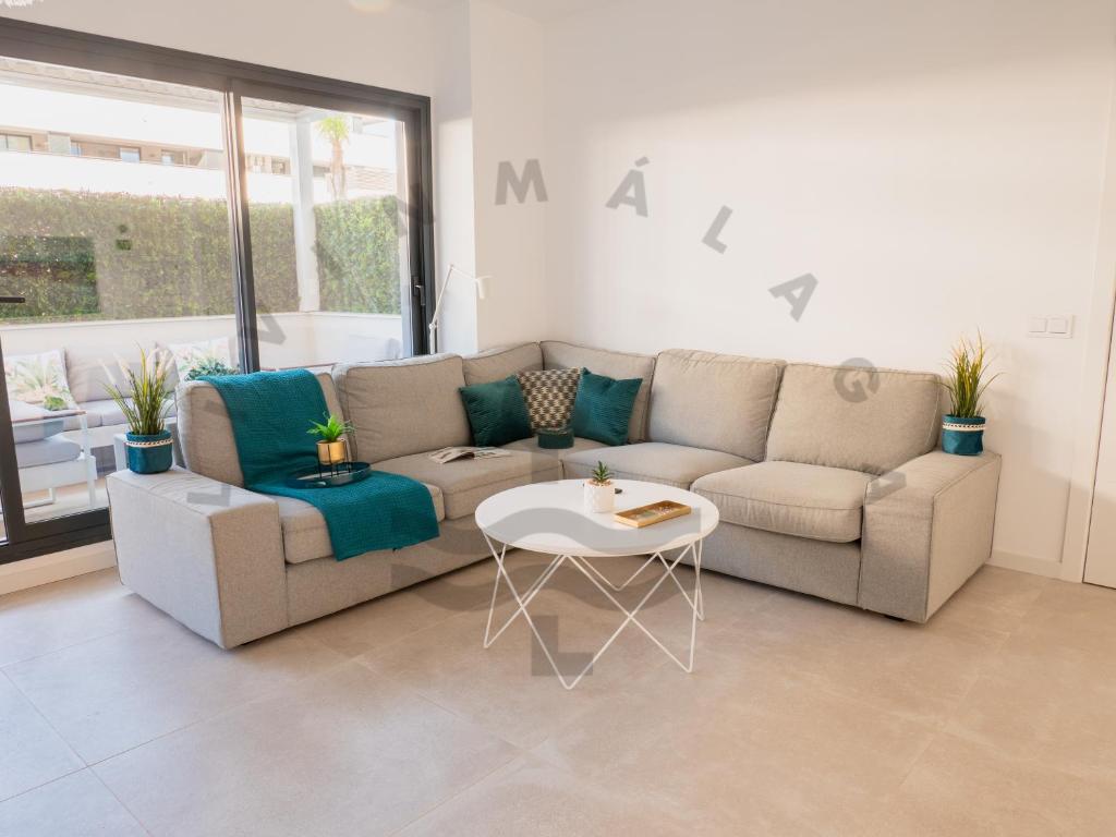 een woonkamer met een bank en een tafel bij LivinMálaga Los Álamos Suites in Torremolinos