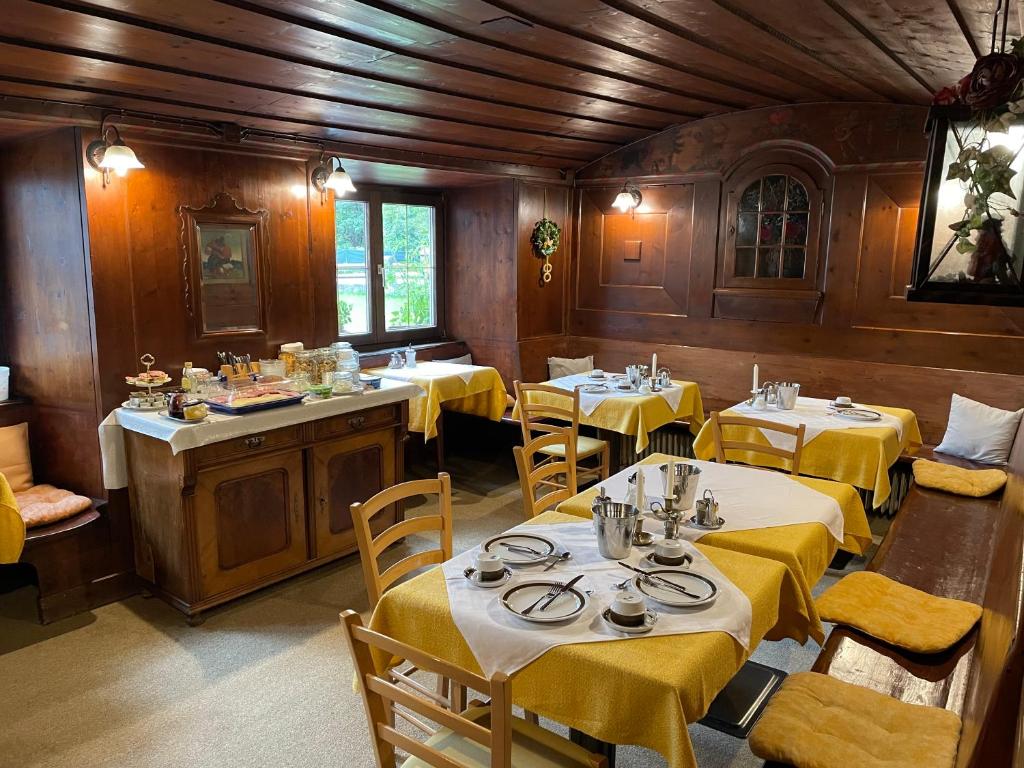 ein Esszimmer mit Tischen und Stühlen sowie einem gelben Tischtuch in der Unterkunft Goldener Adler in Scharnitz