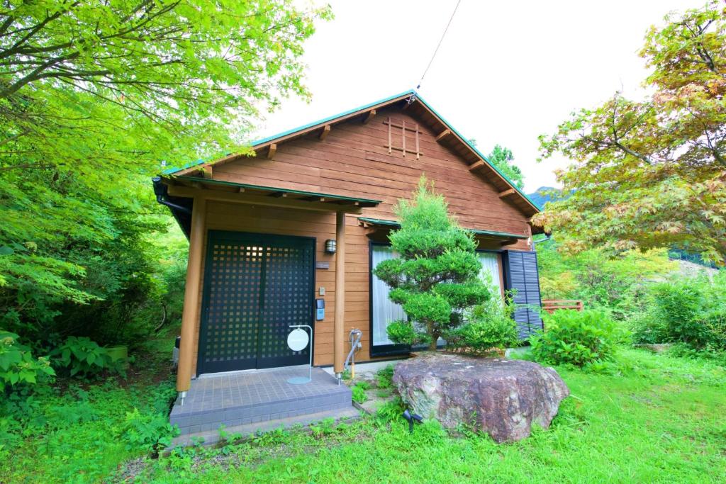 a small house with a tree in front of it at ヴィラ四季の丘 