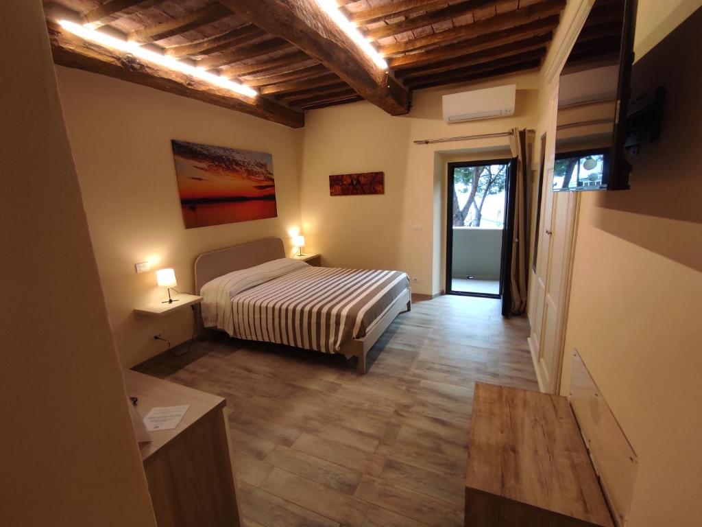 1 dormitorio con 1 cama y puerta a un balcón en The View - Sunset & Relax - Suite - Appartamenti Vista Lago en Passignano sul Trasimeno