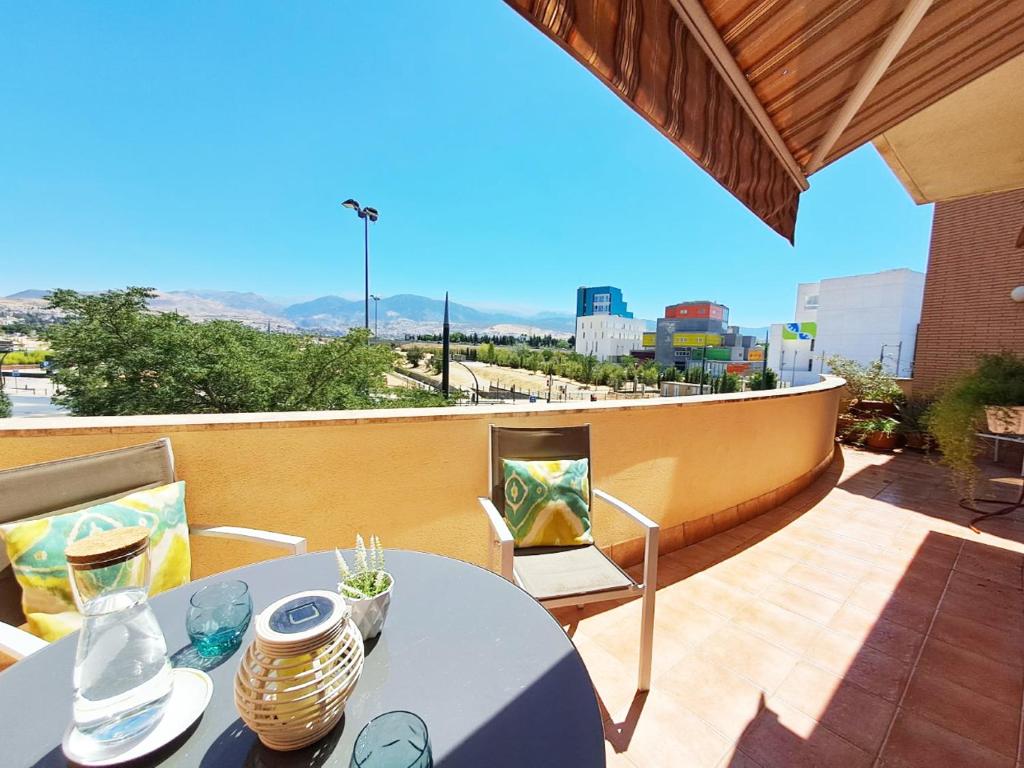 un balcón con una mesa y un ordenador portátil. en Apartamento Gold Sierra Nevada, en Granada