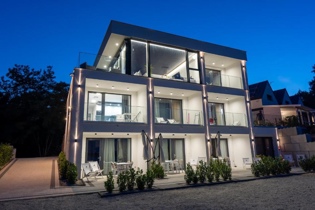 a large white building with windows at night at OW Mewa domki apartamenty nad jeziorem in Nysa